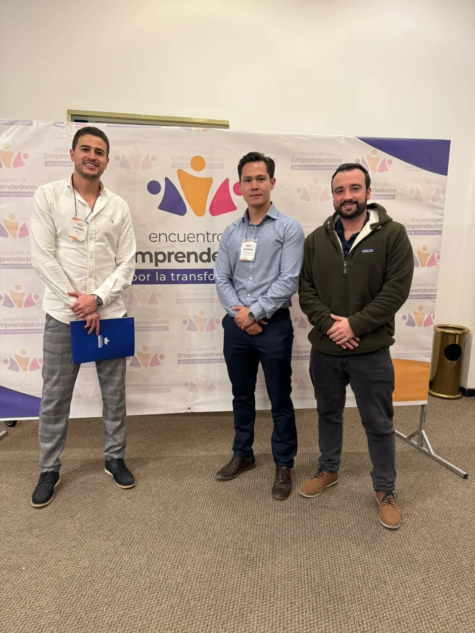 Tres asistentes frente al panel de un encuentro de emprendedores.
